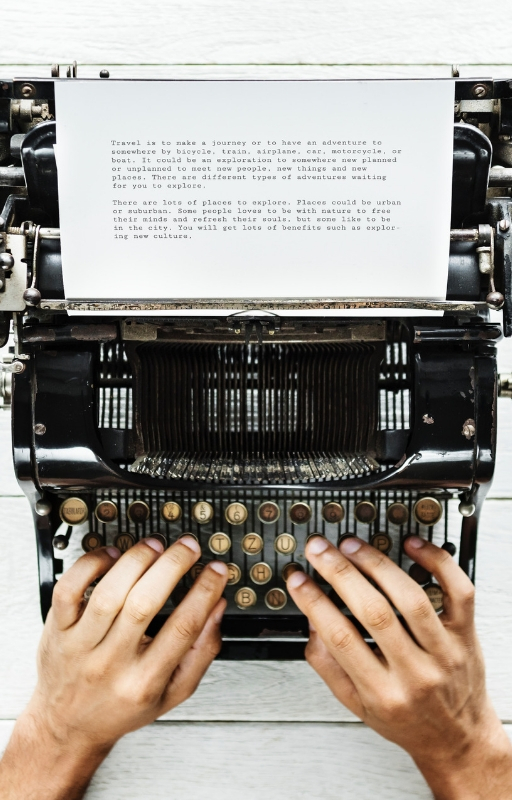 Two hands typing on a typewriter