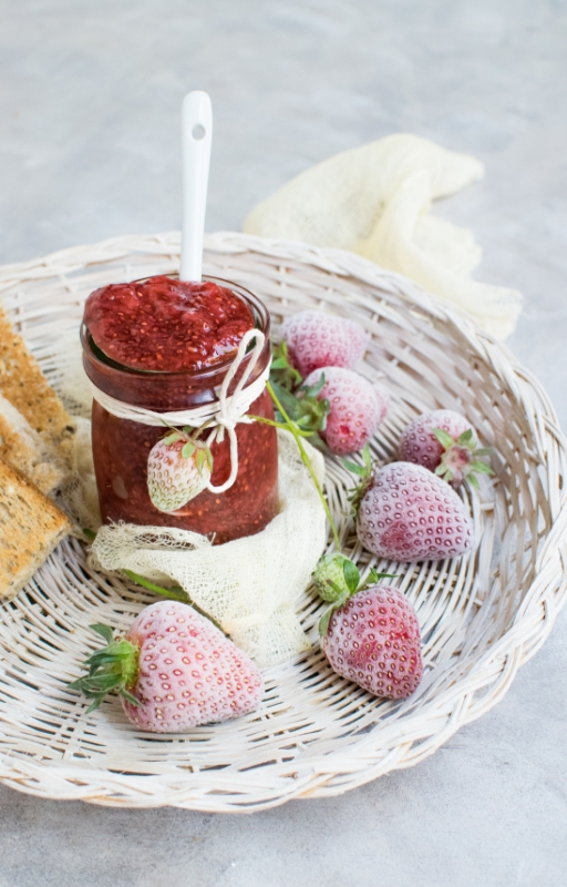 basket of strawberry fruits with jar of jam