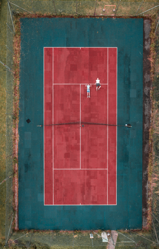 two person lying on tennis court