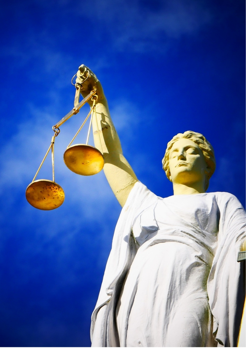 An image of a lady justice with blue sky as the background 