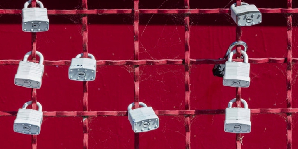 An image of a wire in criss cross position with red background where 8 locks are placed in the wire.