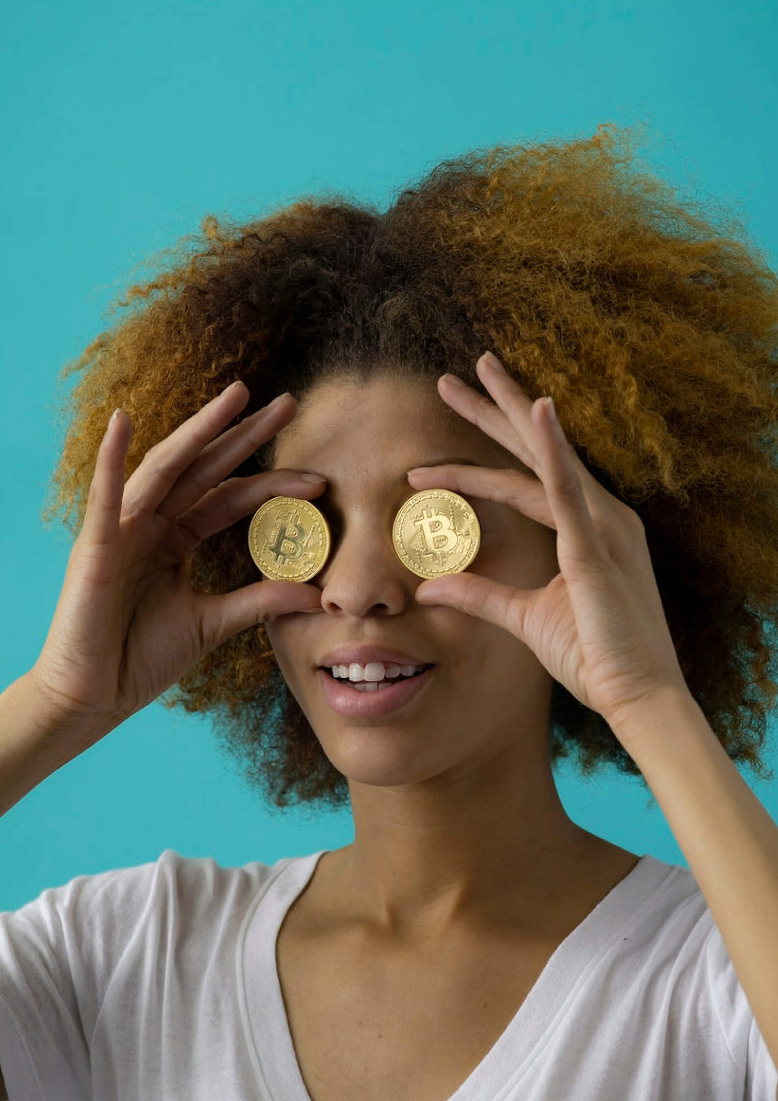 Image of a girl holding gold coins on her eyes 