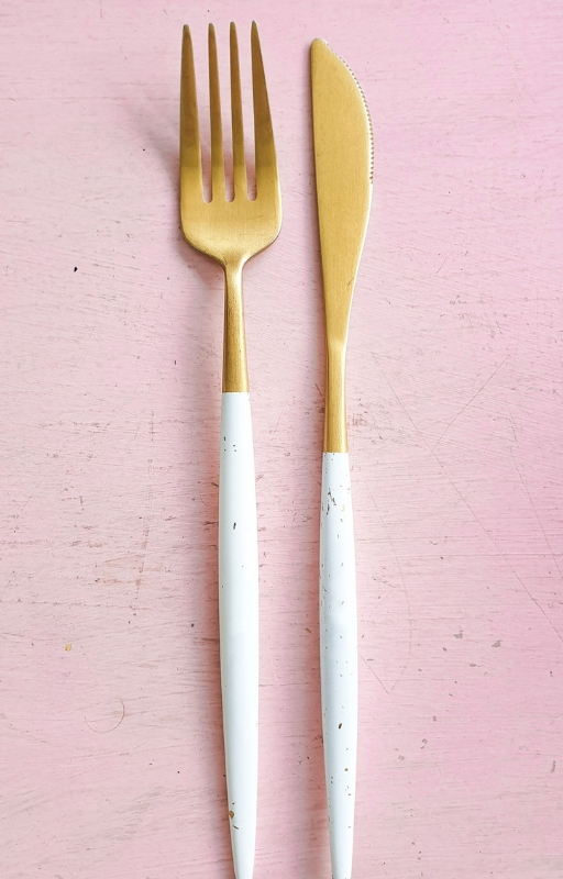 Fork and knife on a pink background