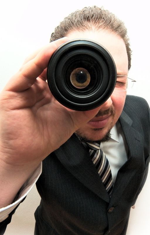 A man holding a binocular against his eyes