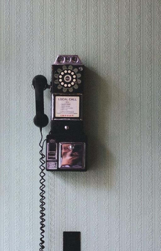 Vintage telephone hanging on grey wall
