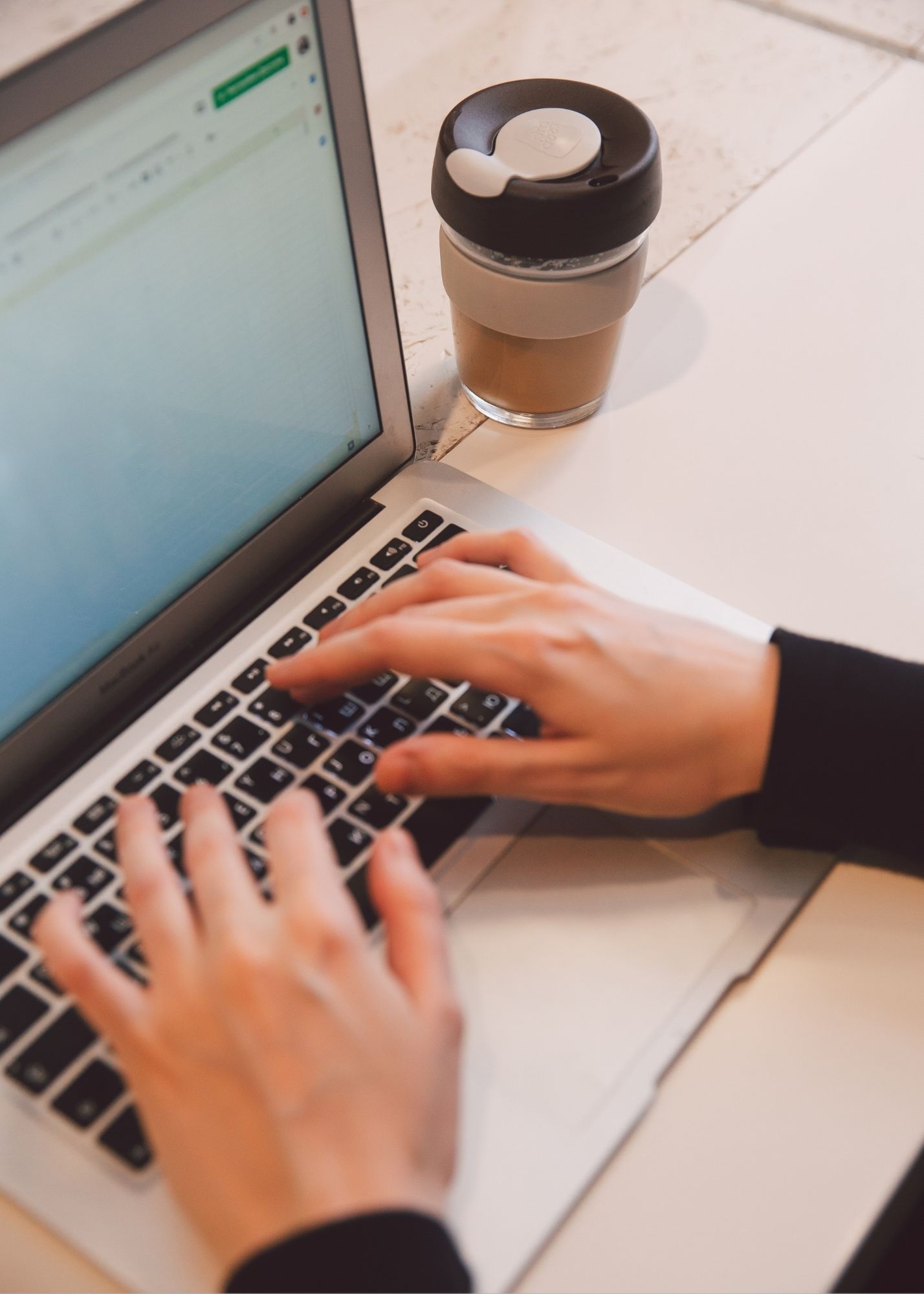 A man's hands can be seen working on a computer. 