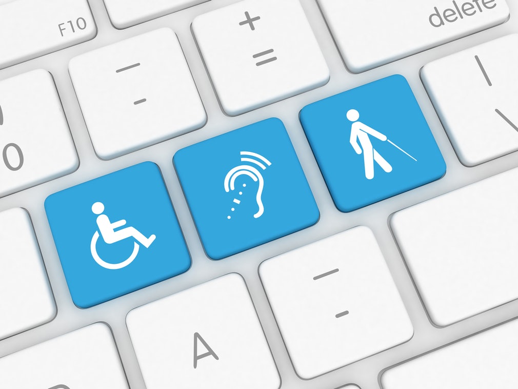 three blue keys with a man in wheelchair, ear, and a man walking with a stick on a white keyboard