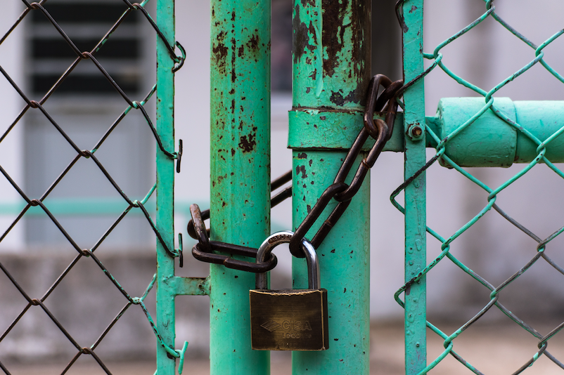 A house lock put up on a green coloured structure