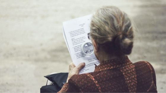 woman reading with magnifying glasses
