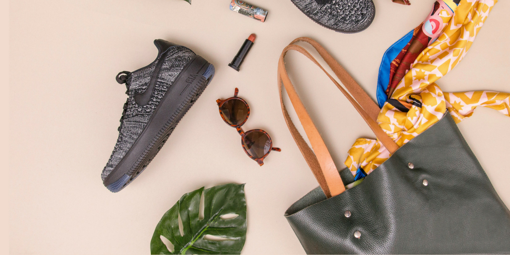 decorational image with a leaf, a pair of shoes, bag, sunglasses and lipstick