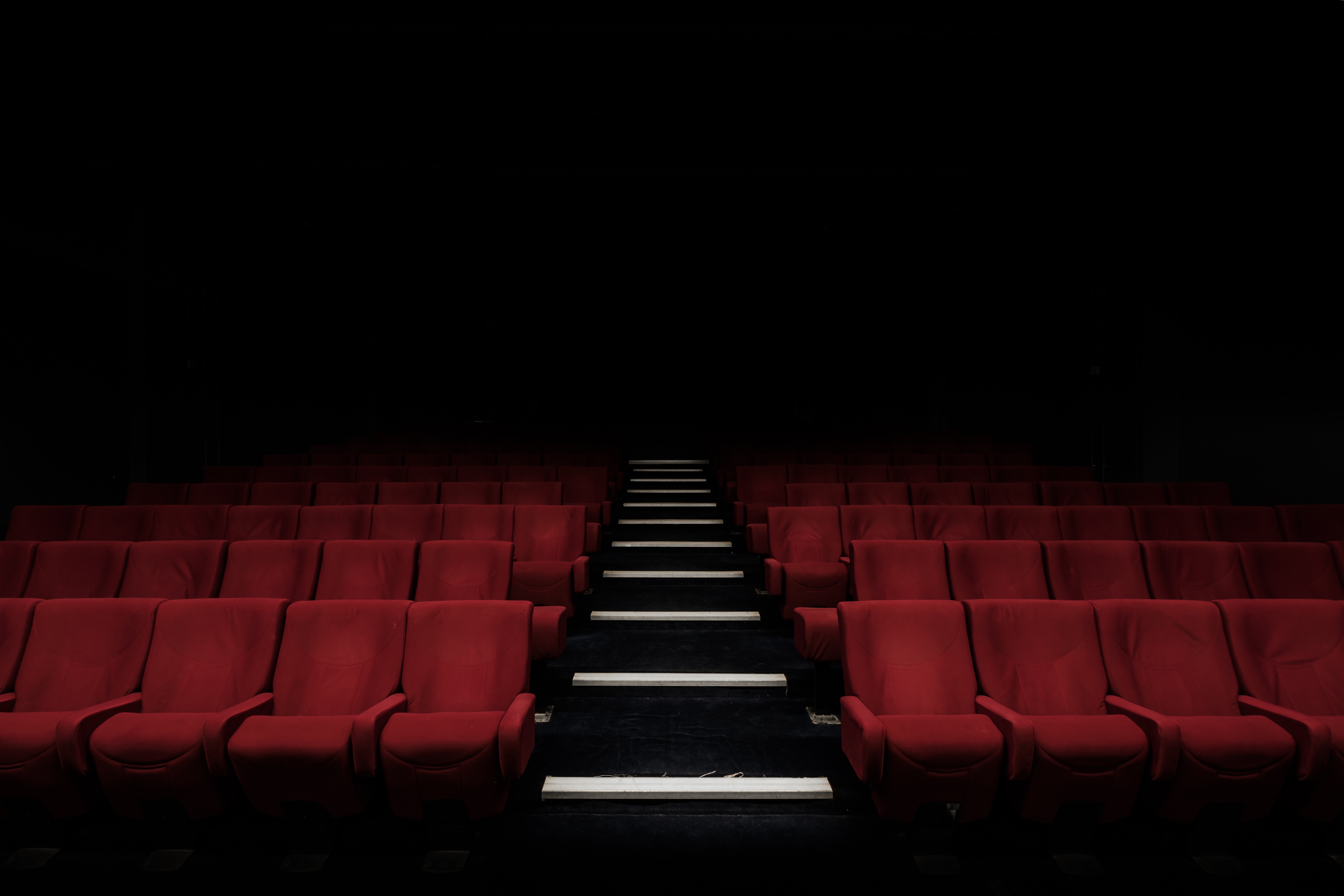 Interior of cinema hall with red chairs