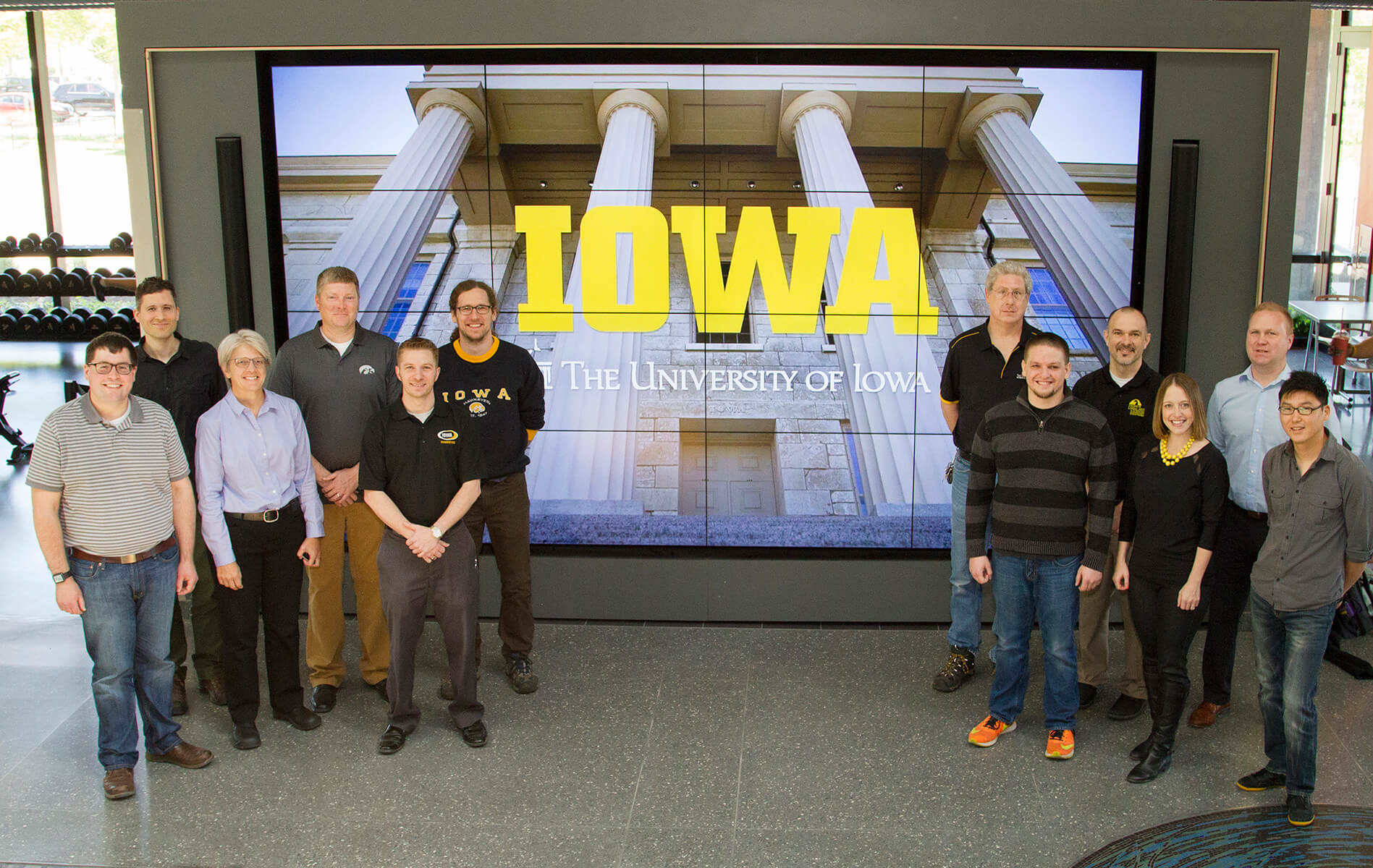 People standing at the sides of the screen showing the pillars and the word IOWA