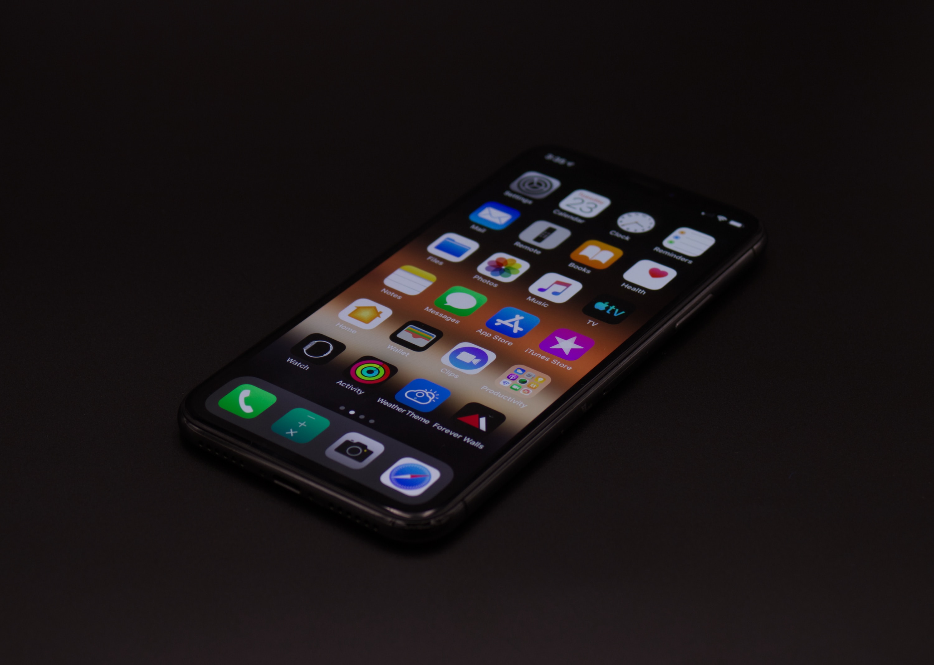 an illustration of a turned-on space gray iPhone X mobile showing different apps on the screens with a black background portraying for drupal mobile solutions