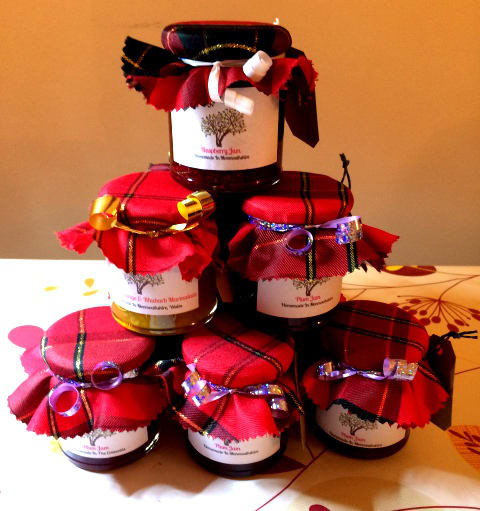 Jars stacked together consisting an image of a tree on them and a red cloth over the lid.