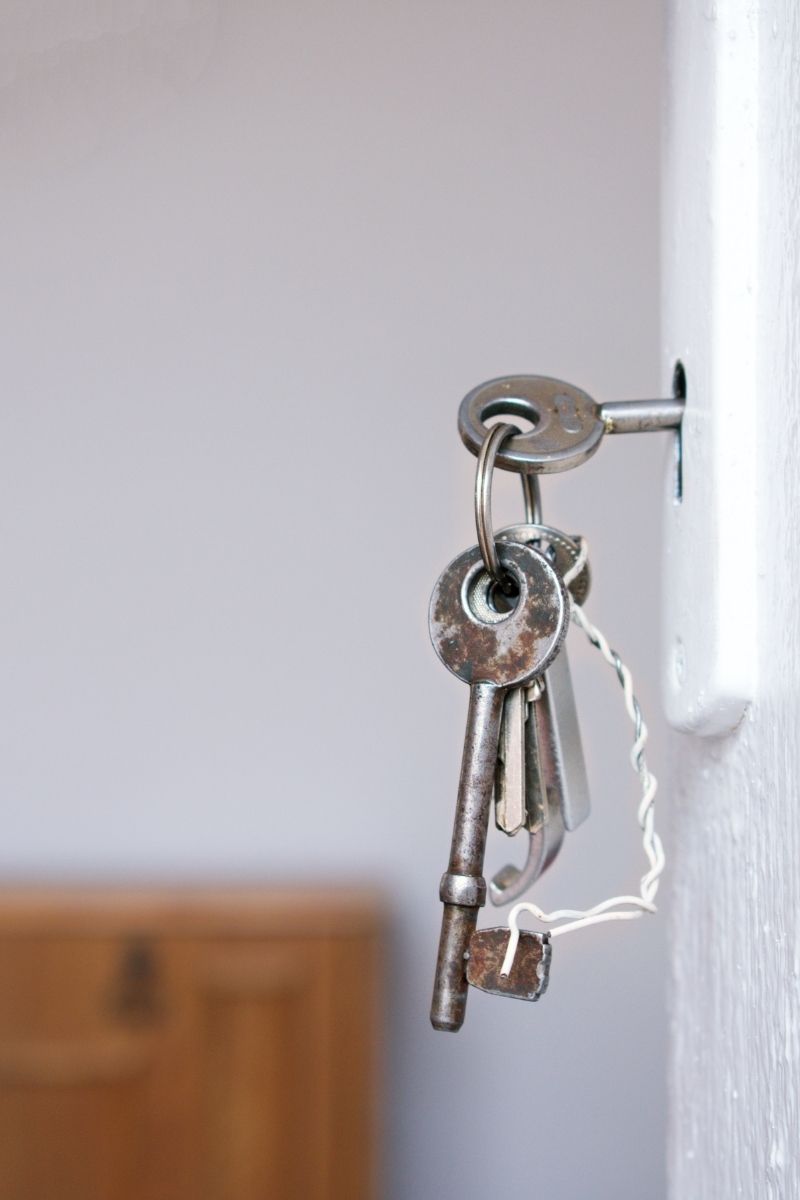 A set of keys is seen pushed into the lock of a door.