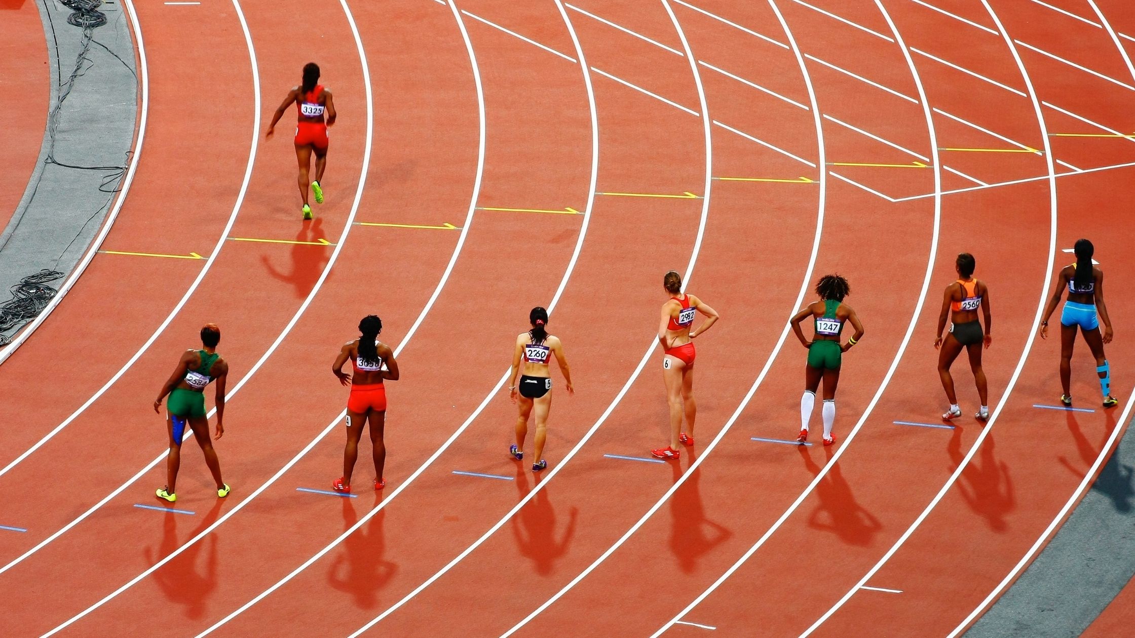 Athletes are seen standing on the start line of a race.