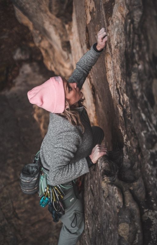 A woman is climbing a mountain.