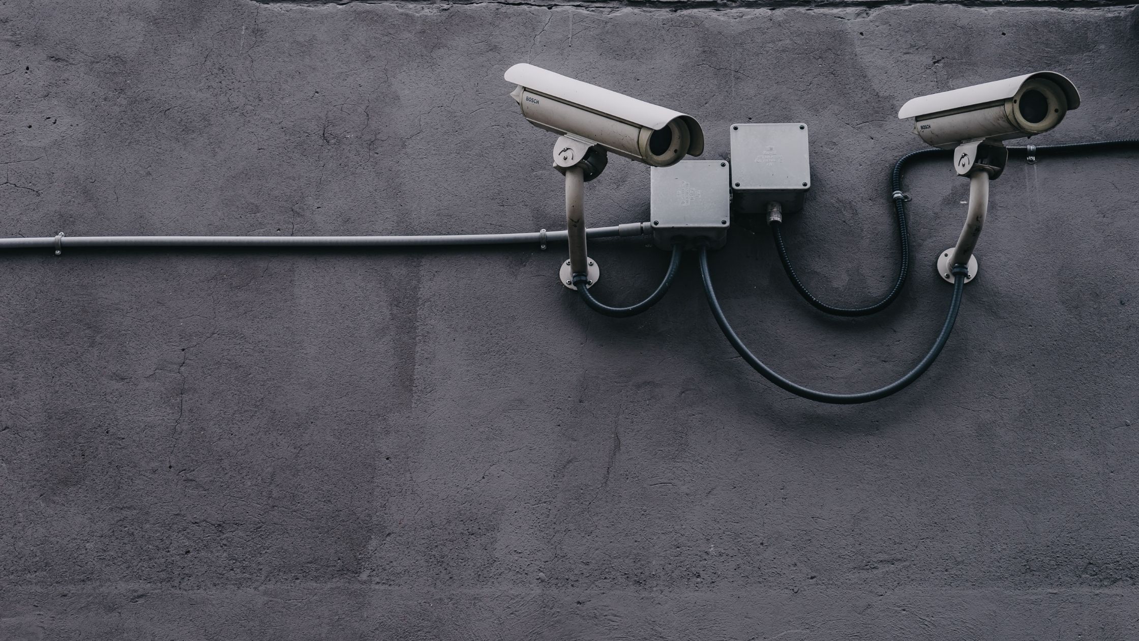 A pair of security cameras are mounted on a wall.