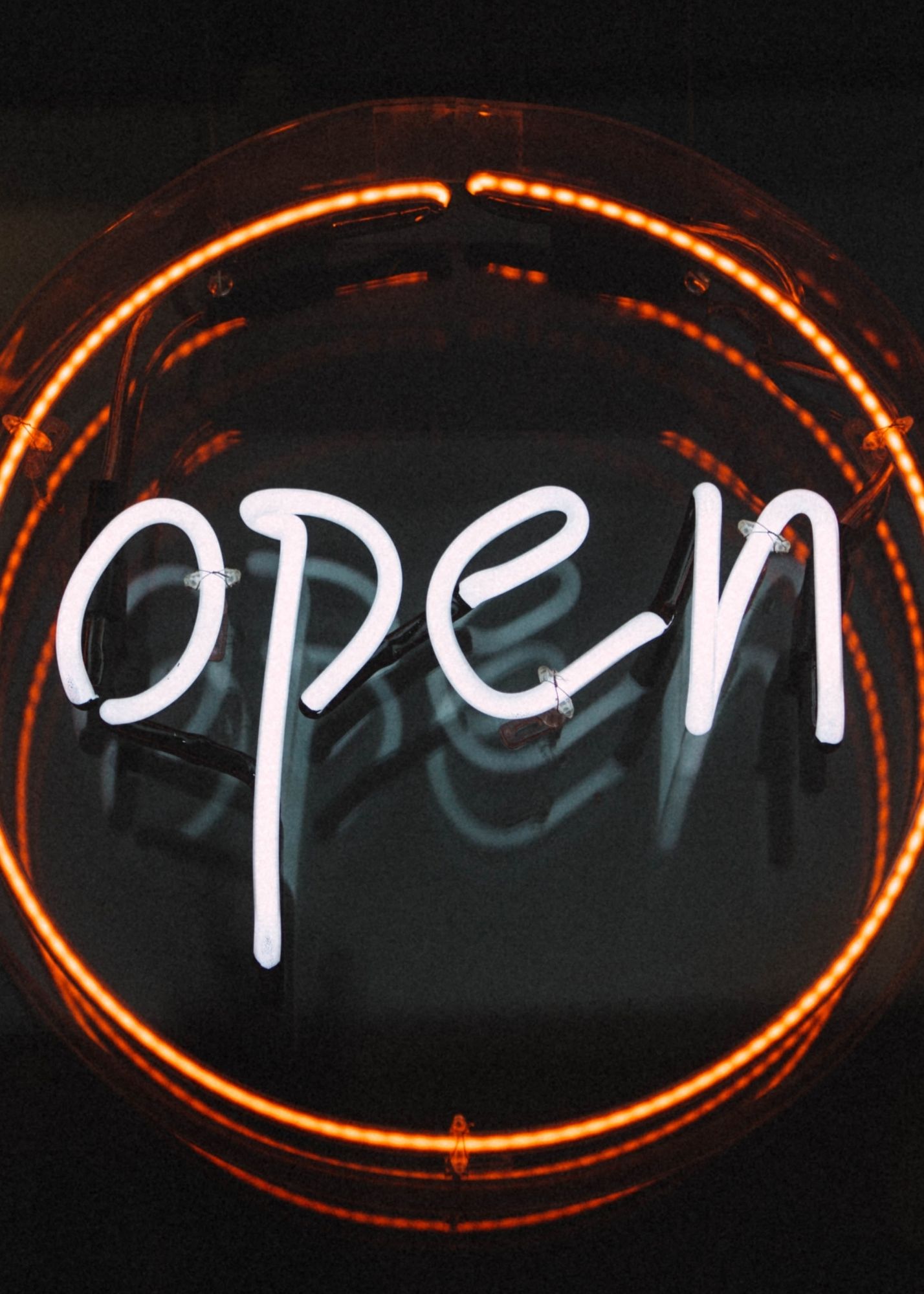 Open is written inside a red circle on a black background.