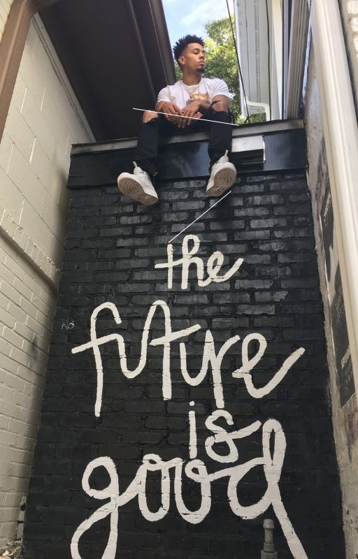 A man is sitting a ledge with 'the future is good' written below him.