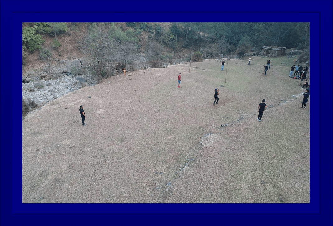 drone shot of people playing cricket in a ground