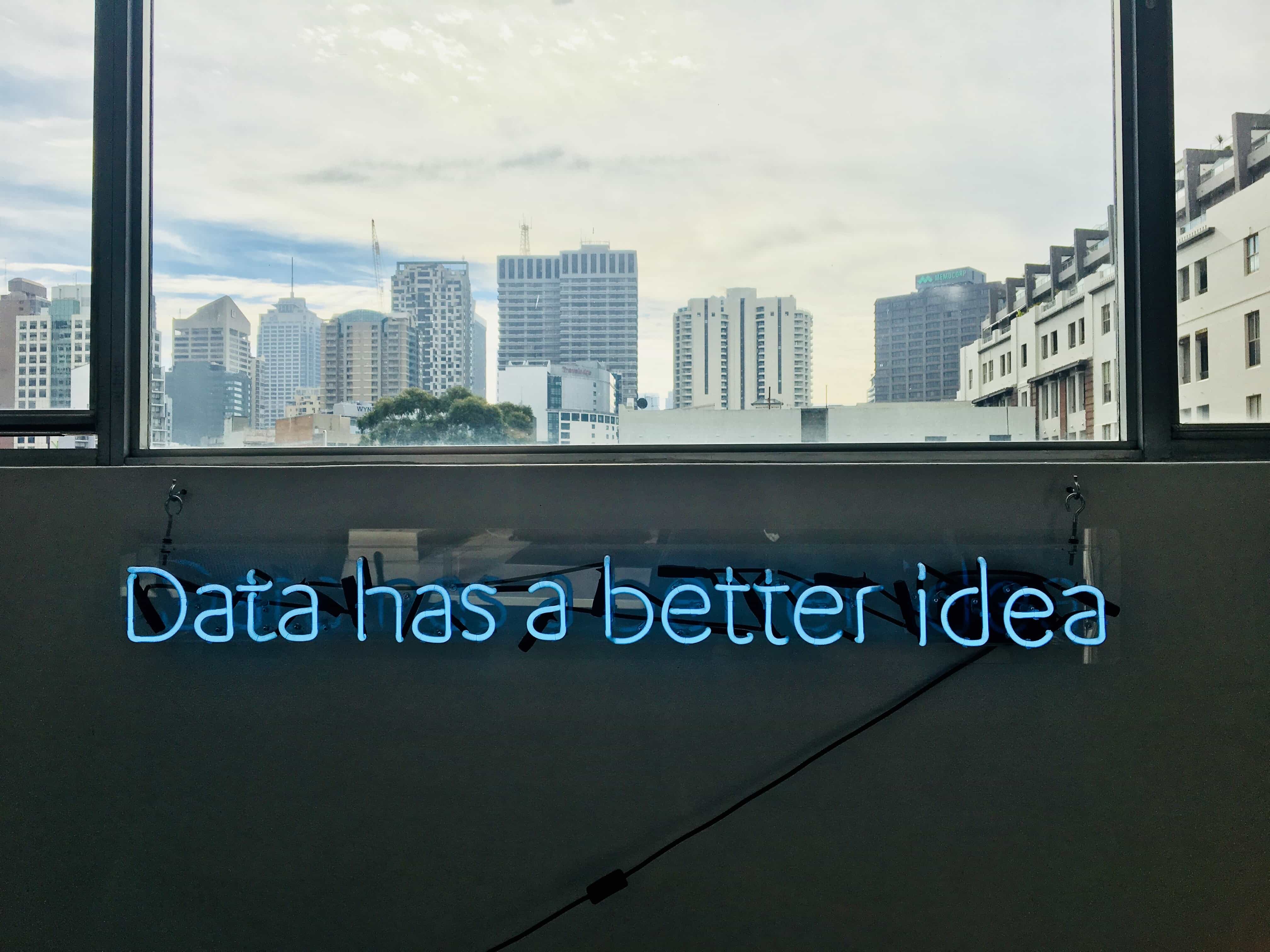 An image to represent Customer Data Platform ( CDP ) with "Data has a better idea" written in the centre, transparent glass window in the background showing building at a distance,