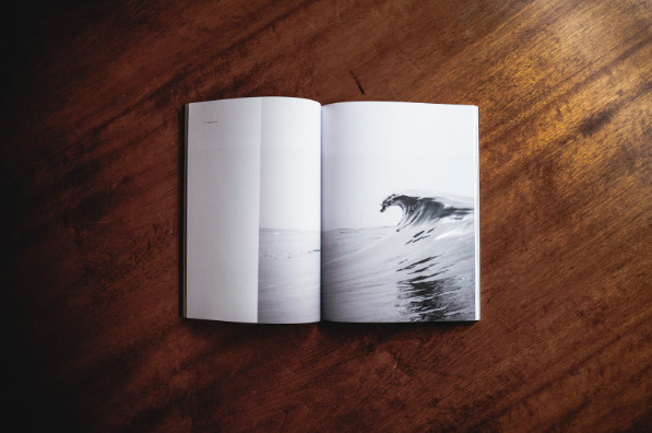 An open book, showing an image of ocean tides, kept on the table