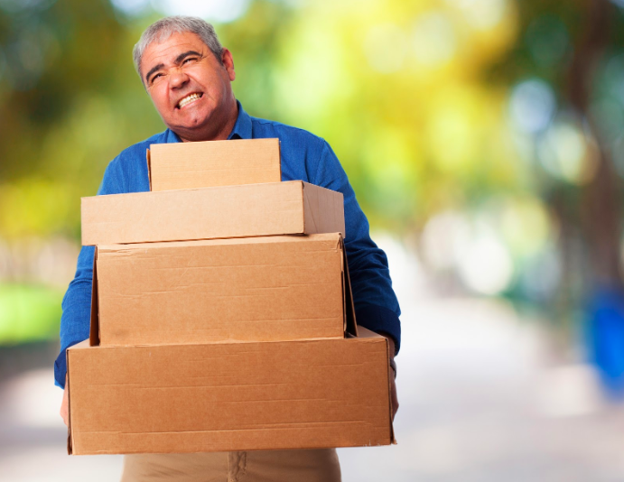 An elderly man lifting four loaded boxes