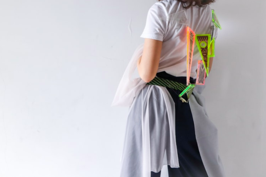 Illustration image, representing design thinking, showing a back-facing girl in white, blue and green color clothes with a series of triangle shapes designs attached in a wire enclosed around her neck