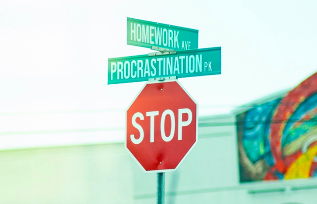 A sign board on the roadside reading 'homework, 'procrastination' and 'stop'