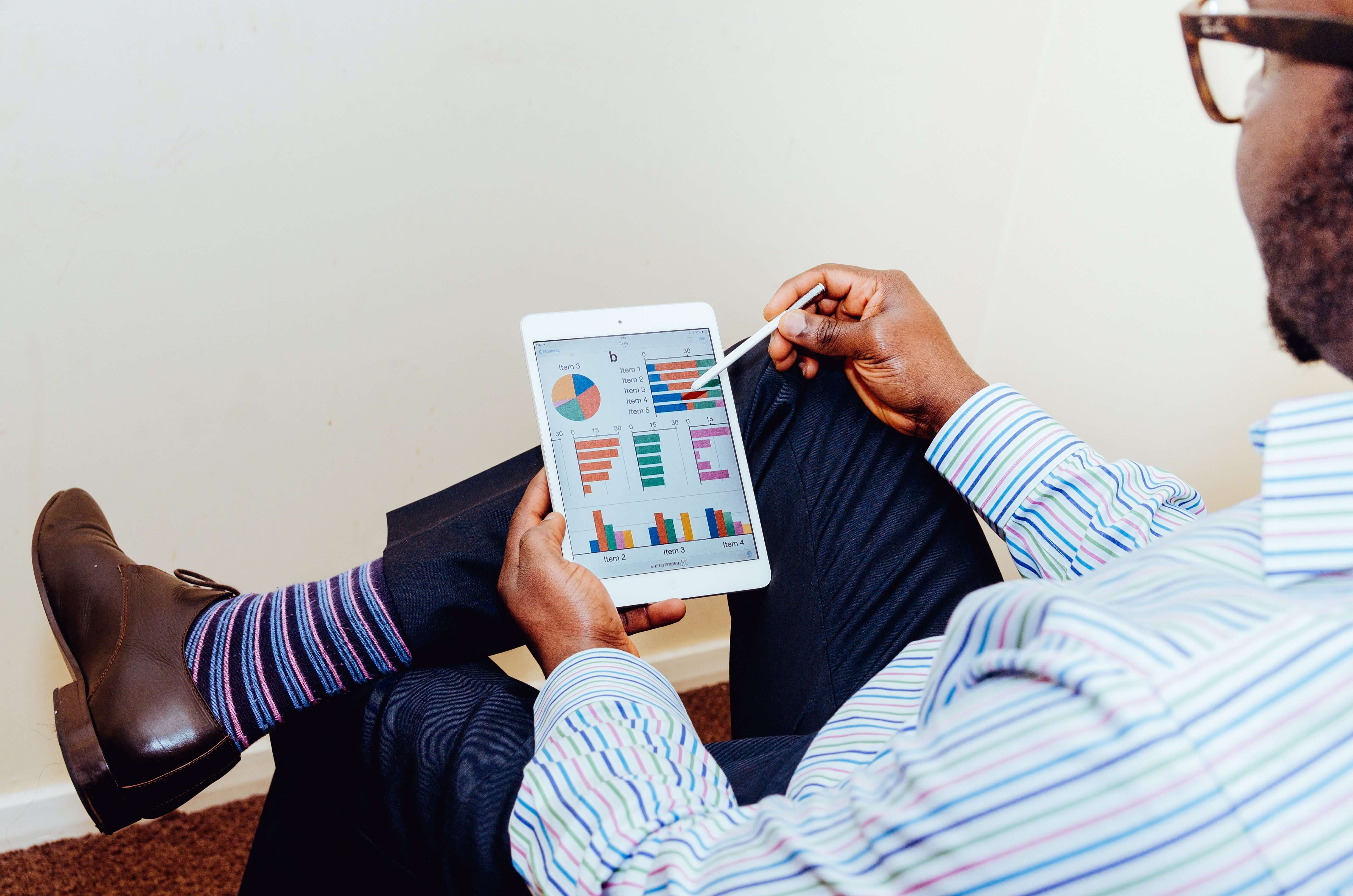 Customer data platform ( CDP ) represented through a man looking at a graphical representation on tablet screen