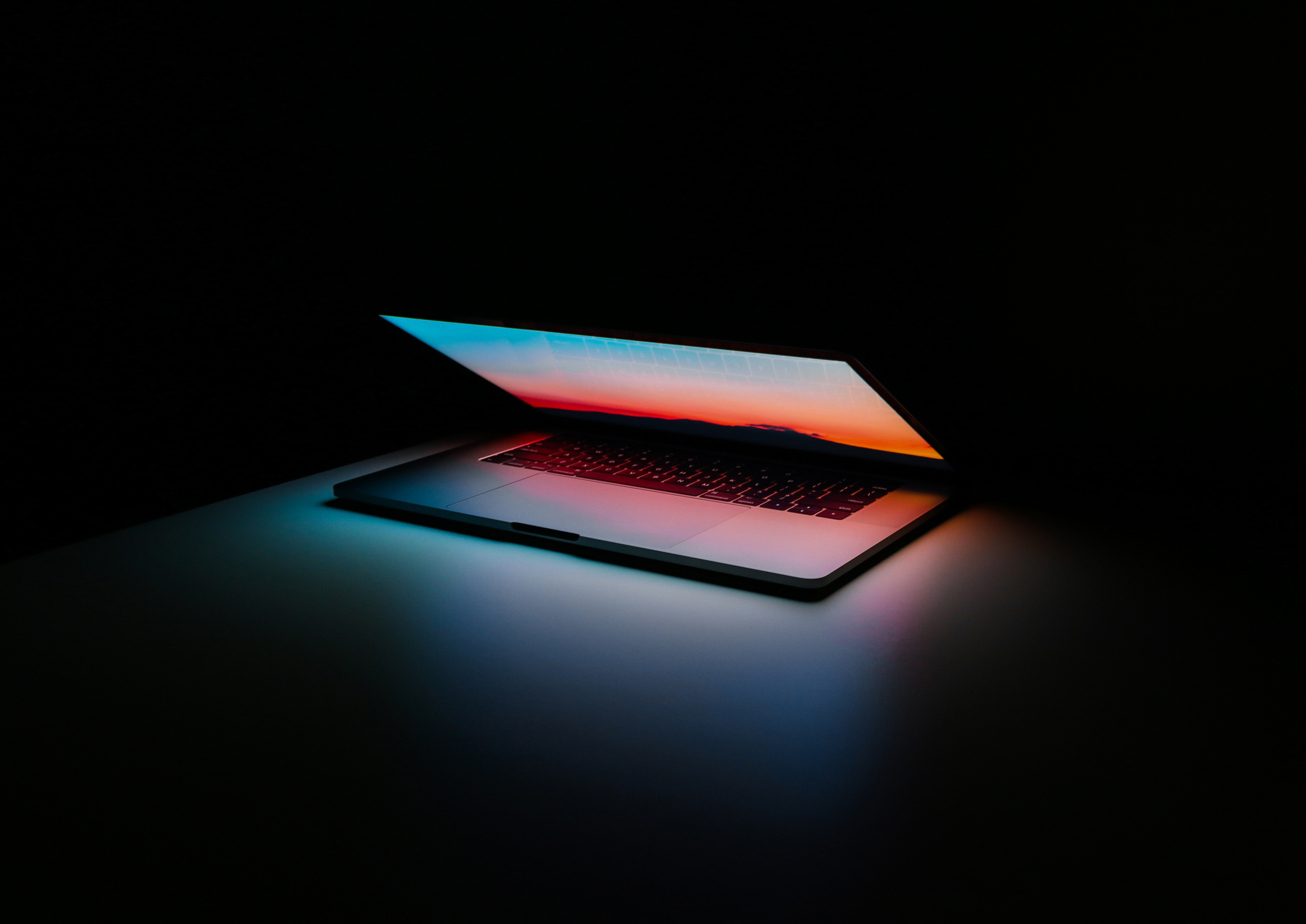 a laptop half open against black background