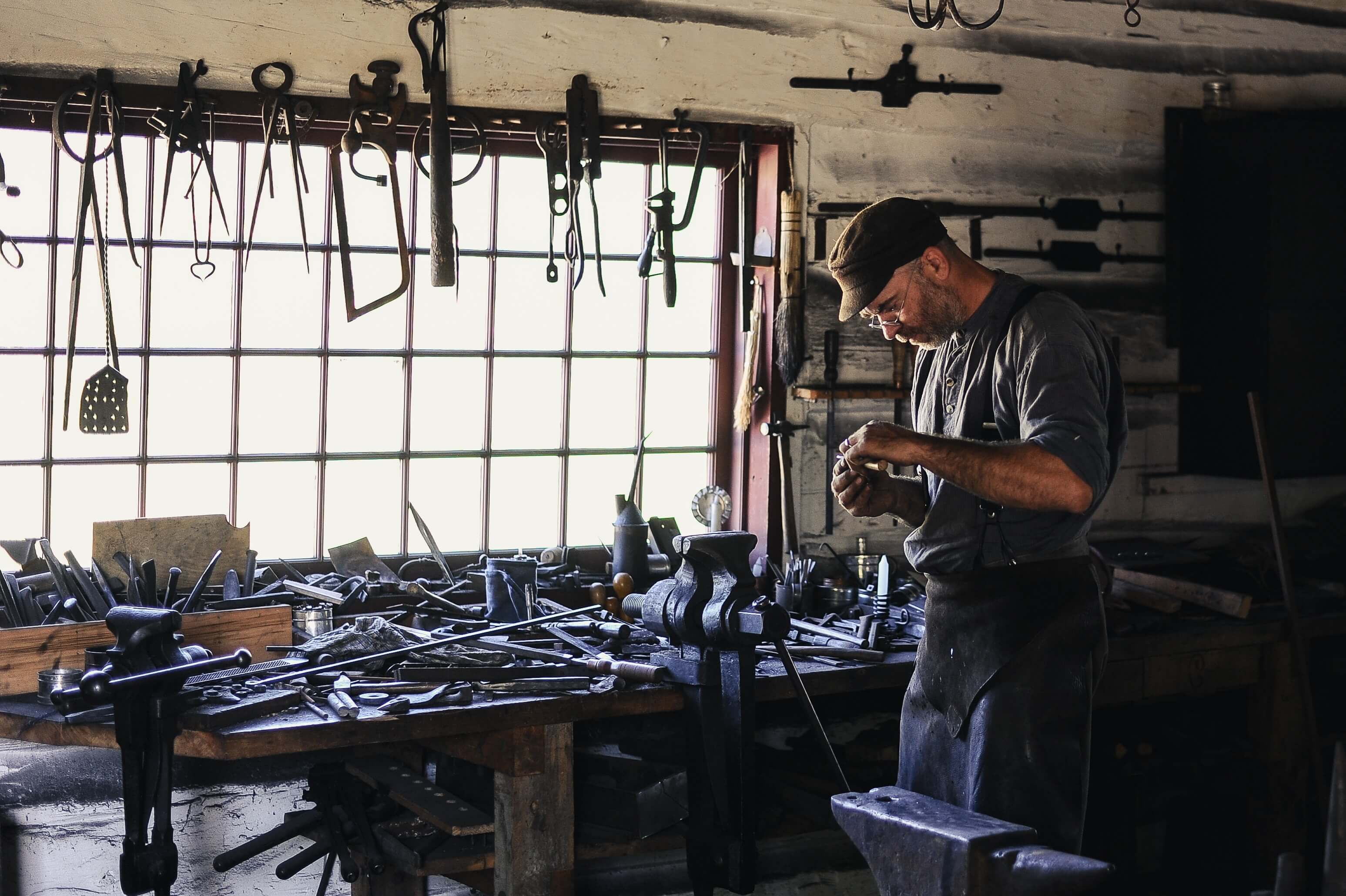 A metalsmith working in a room full of metal objects