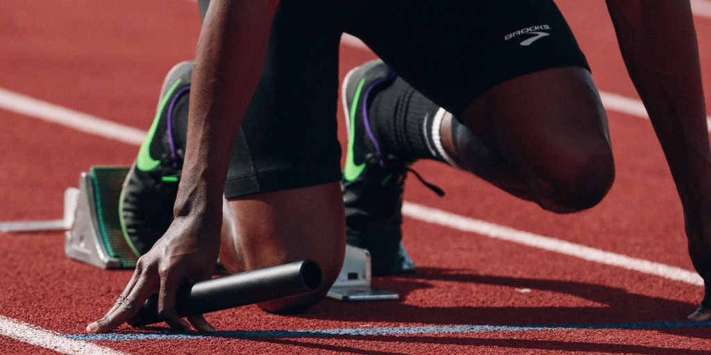 a man holding the rely for the race on ground ready to run