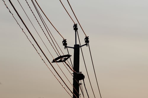 Illustration image showing black communication tower with electricity cables in the evening under a grey sky