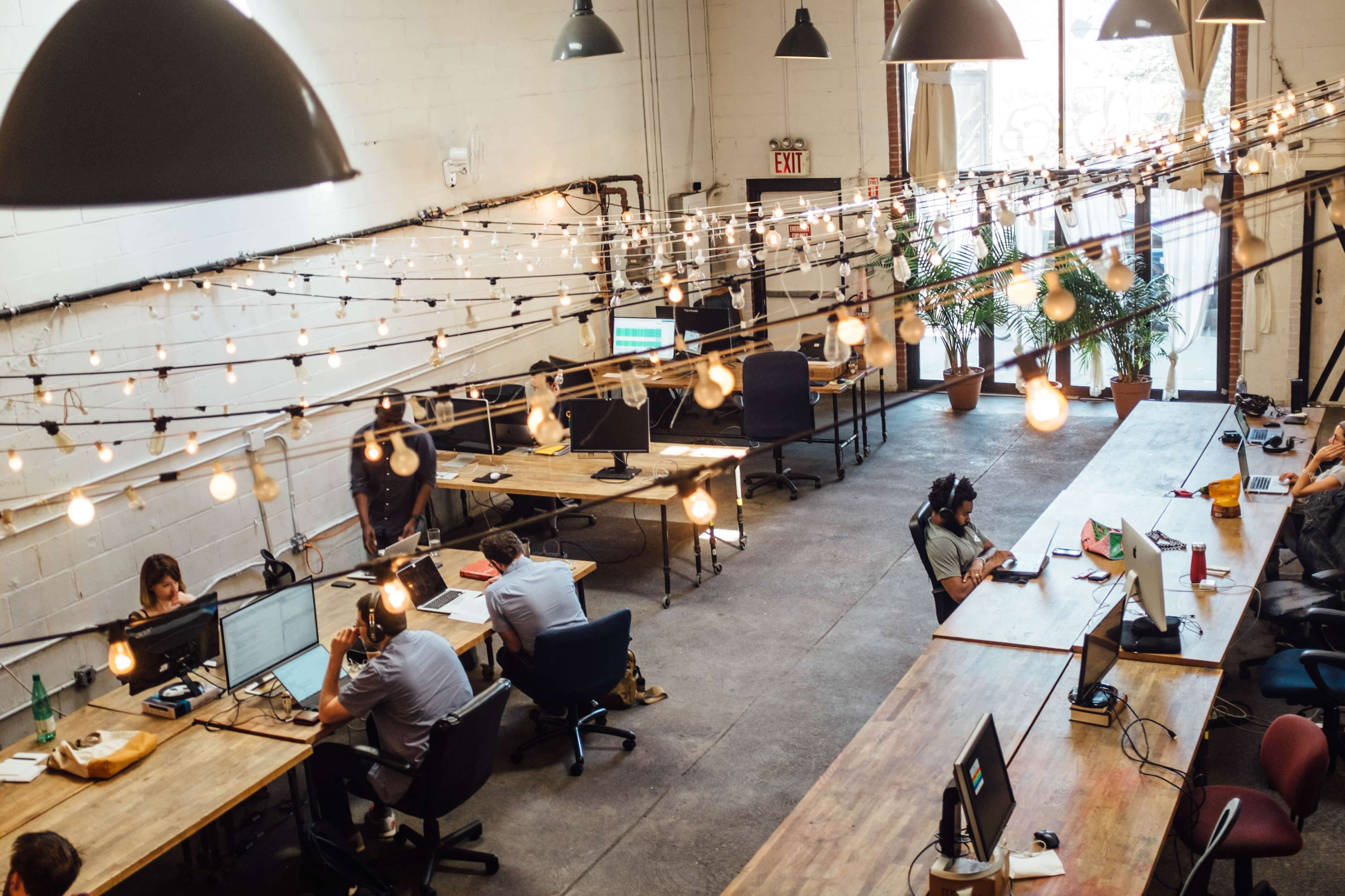 Top view of workplace showing people sitting in front of computers