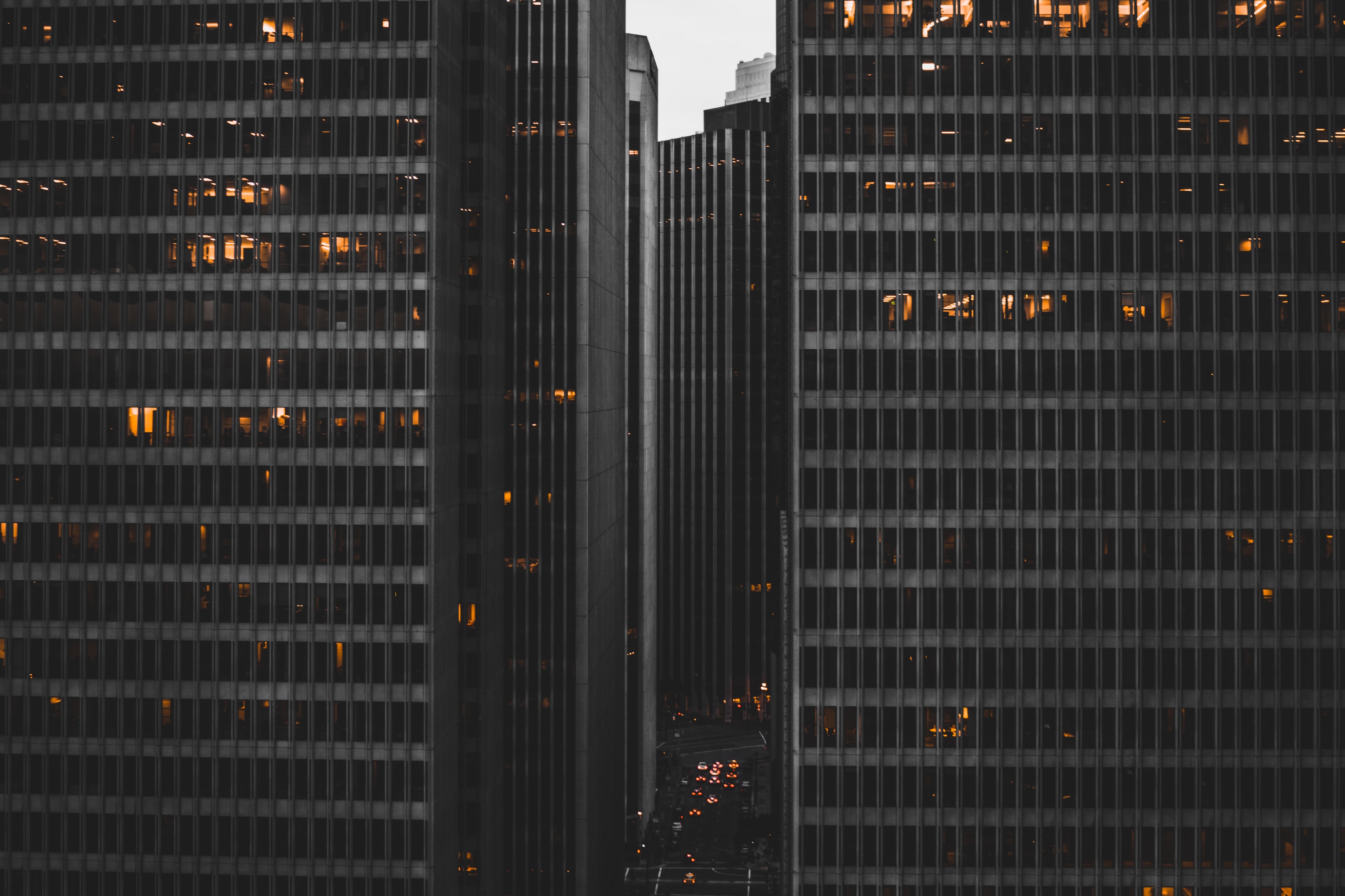 illustration image showing a grey coloured high rise buildings in the evening with lights turned on inside the rooms