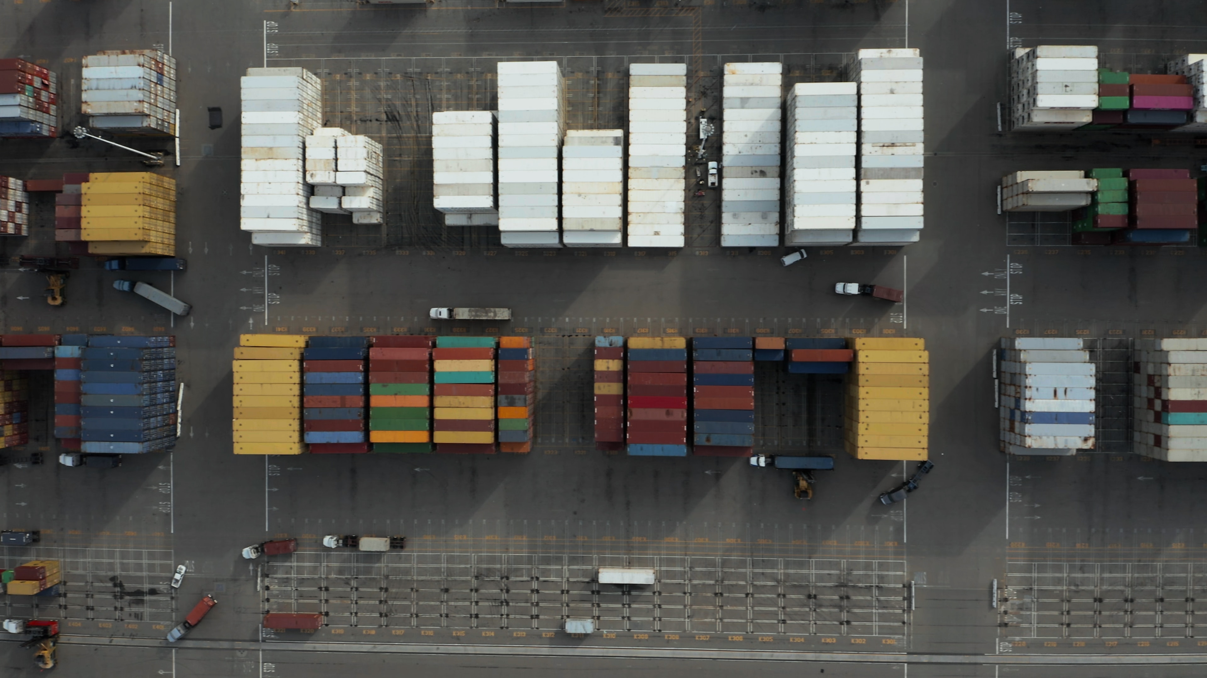 illustration image showing an aerial photography of multicolored trailers during daytime on the road