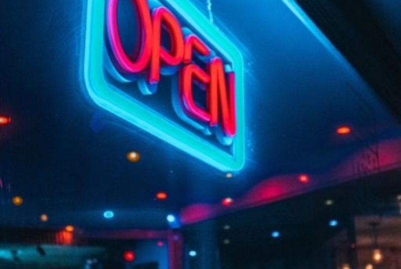 front view of a shop at night with open written on a banner