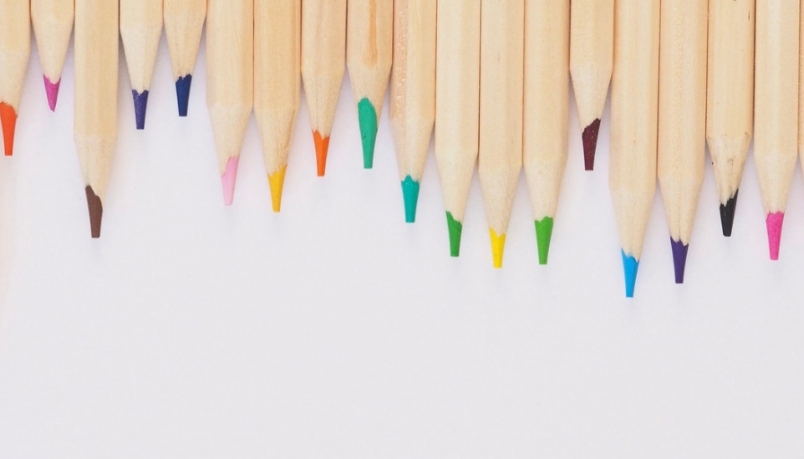 Image of coloured pencils place at the top of the white background 