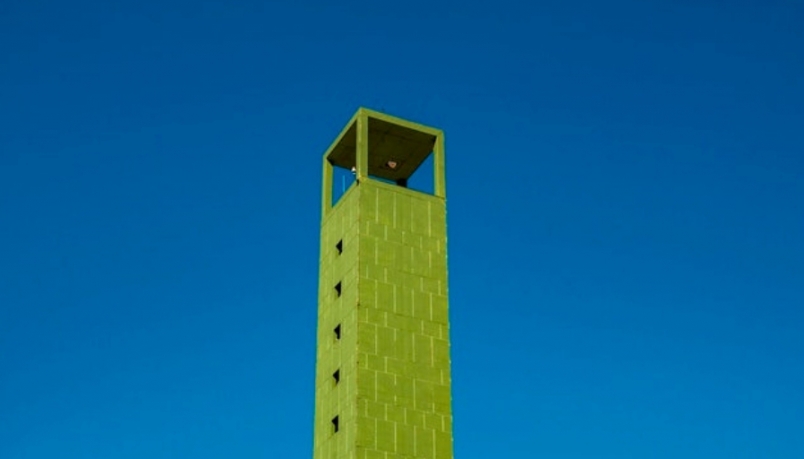 Image of a tall green building with a blur background 