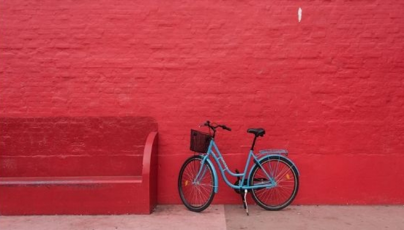 Blue bicycle against red wall