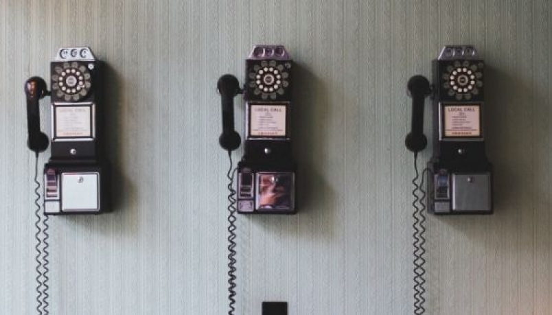 three traditional phones on the wall