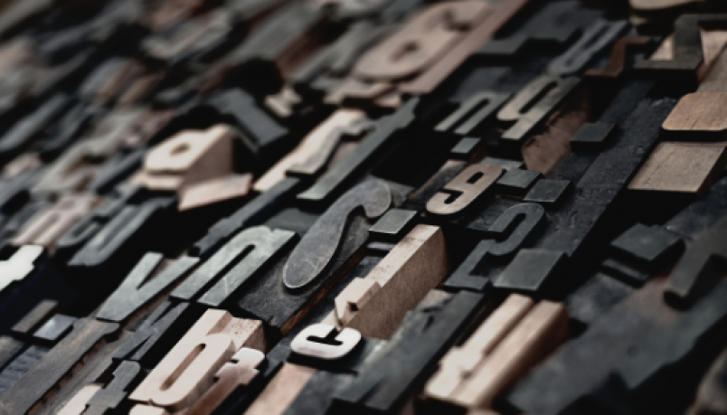 Different English alphabets made out of cardboard scattered around