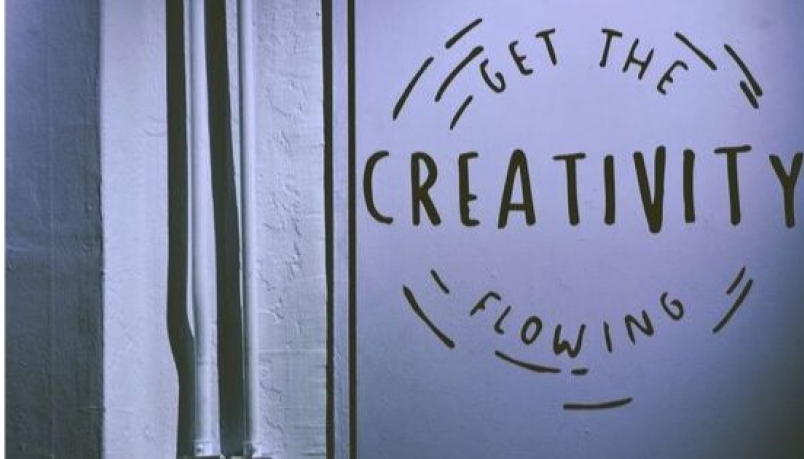Text 'Get the creativity flowing' written on a white wall