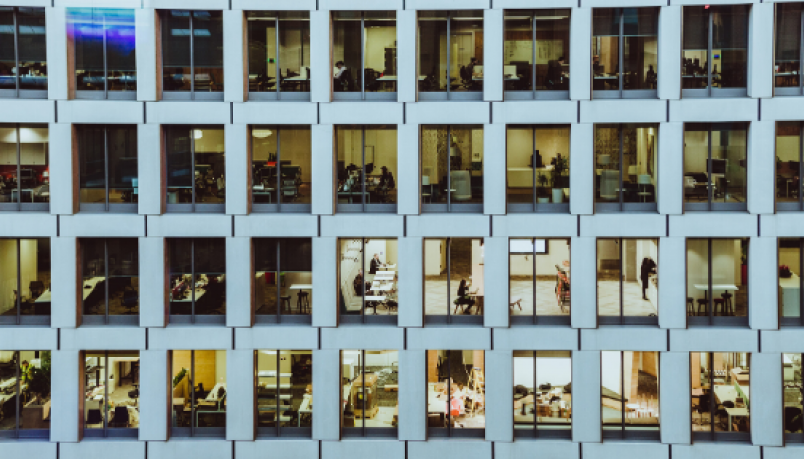 Several windows on a building with transparent glasses showing people in team meetings