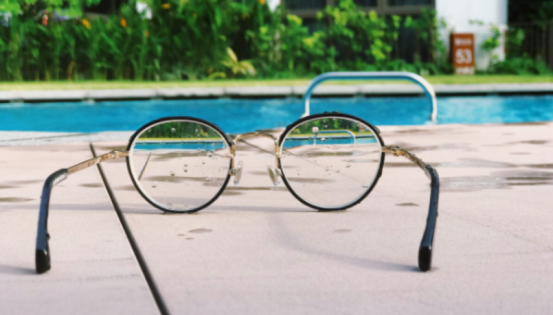 a pair of spectacles placed near a swimming pool