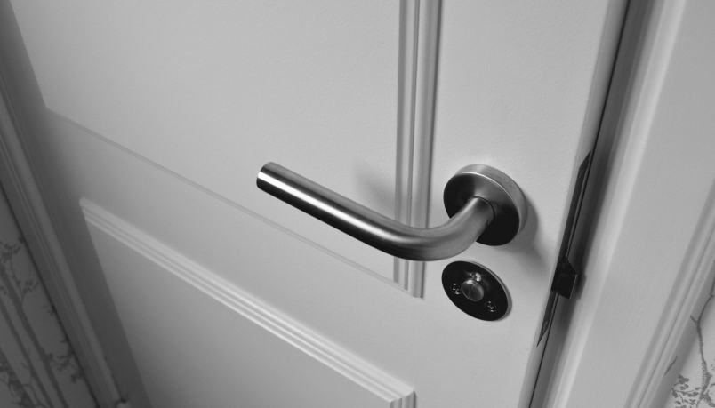 The door handle on a white door can be seen.