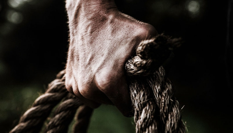 a fist clinching on a roll of ropes