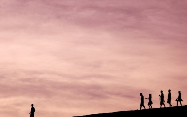 dusky sky with people walking on a mountain